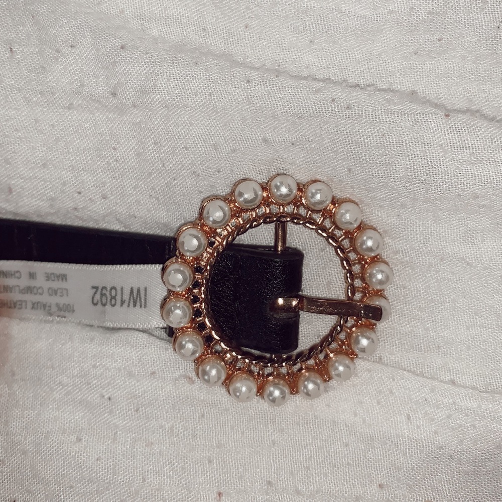 Pearl-studded black leather belt.